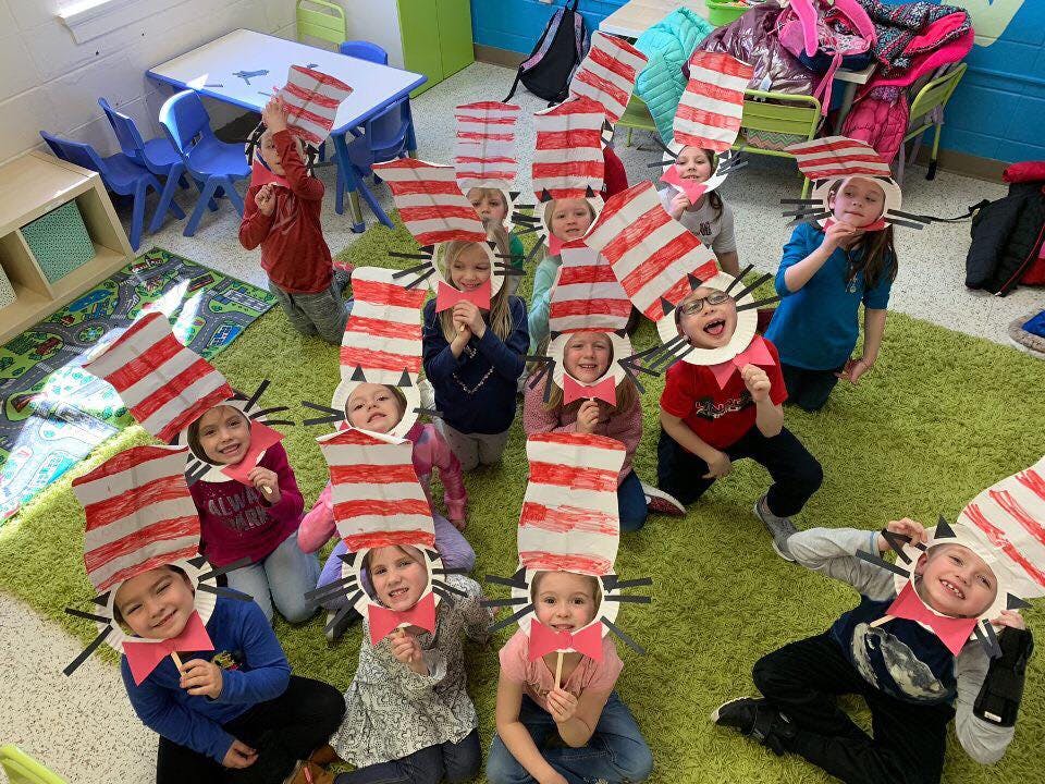 Children wearing red and white striped hats with cat ears