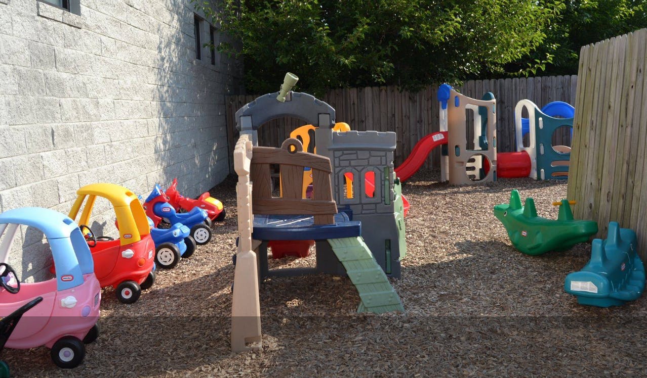 Outdoor playground with ride-on toys and play structures