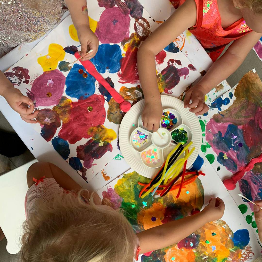 Children painting and crafting with glitter and pipe cleaners