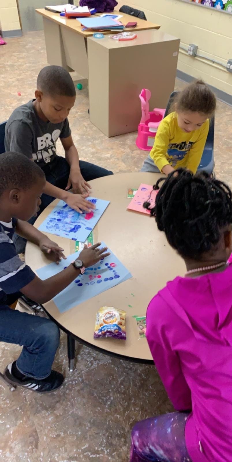 Four children sitting around a table doing crafts