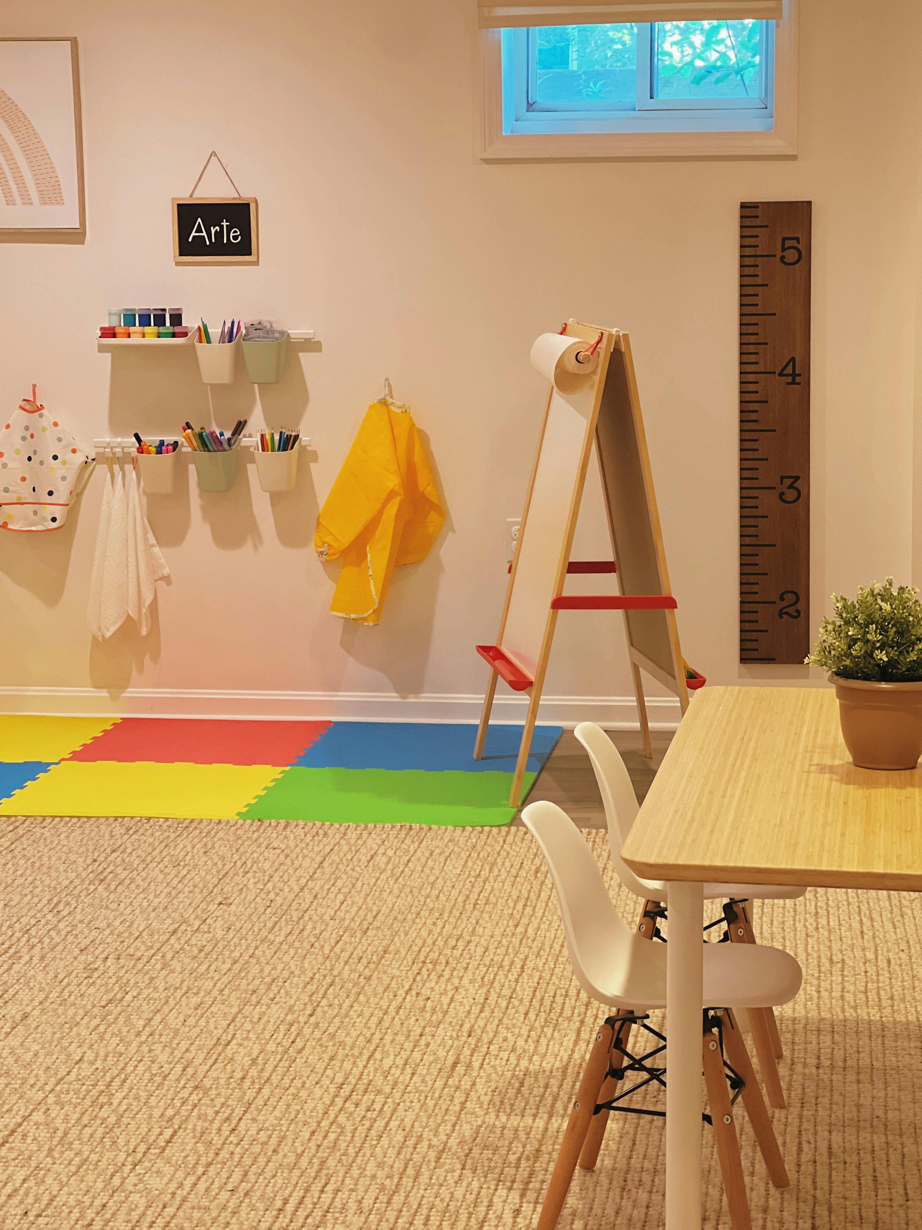 Art area with easel, supplies, and colorful floor mats