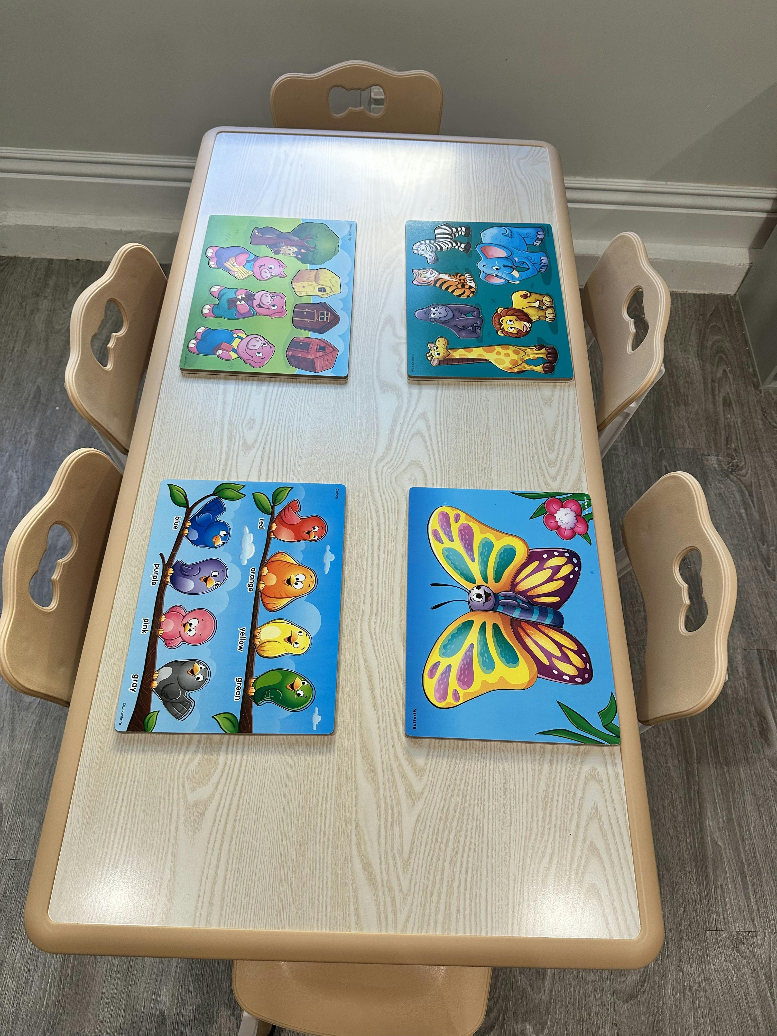 A classroom table with four puzzles: Three Little Pigs, Wild Animals, Colors, Butterfly
