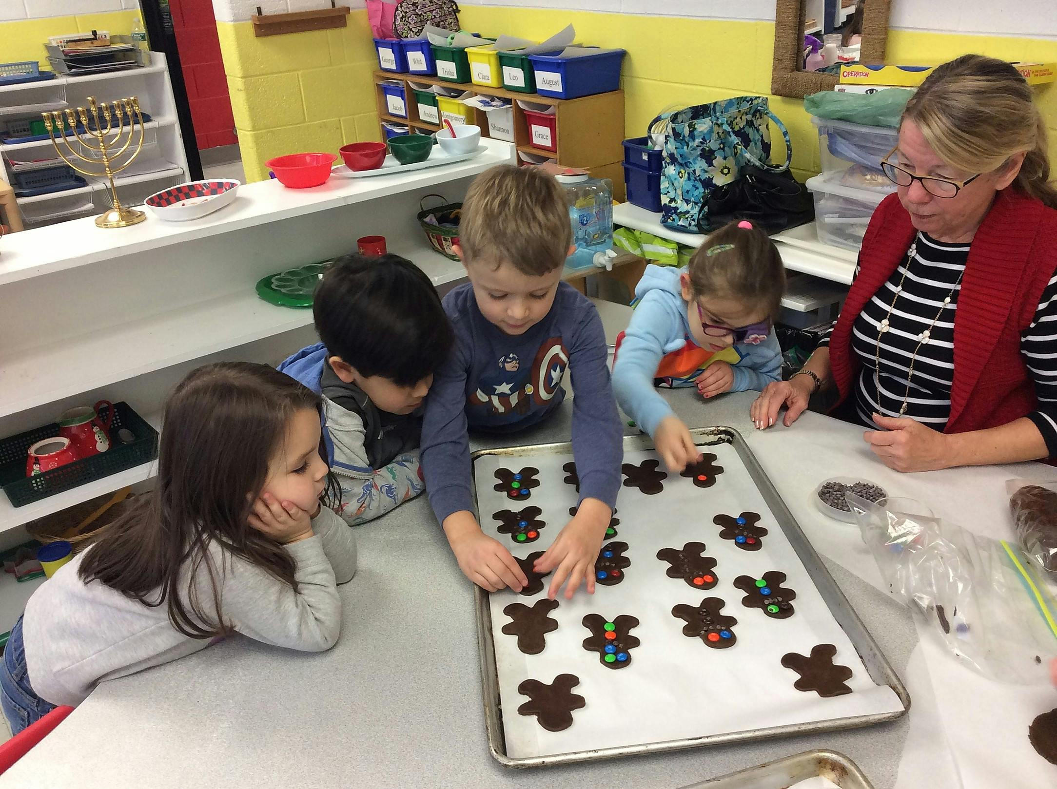 Adult and children decorating gingerbread cookies