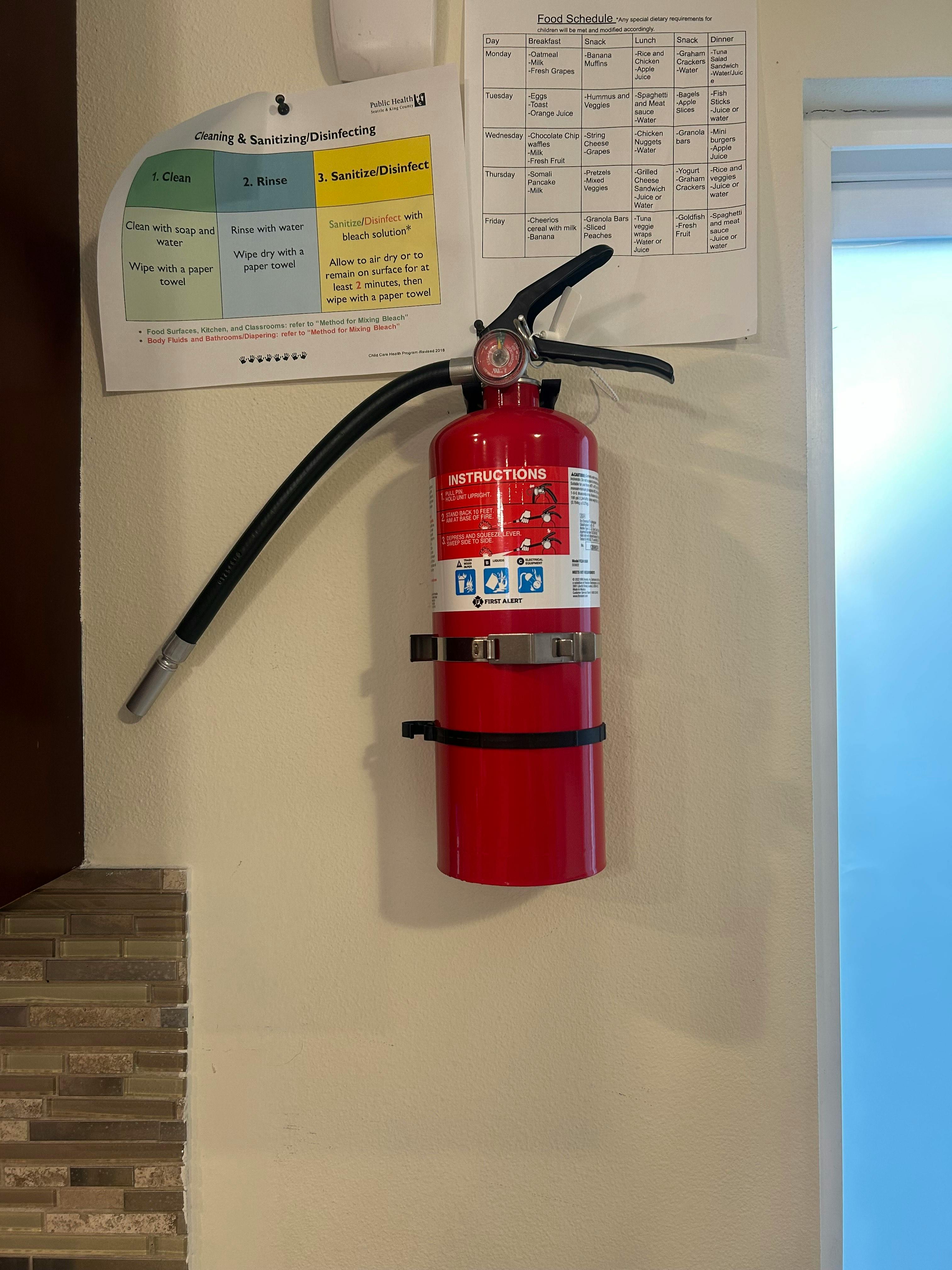 Red fire extinguisher mounted on a wall