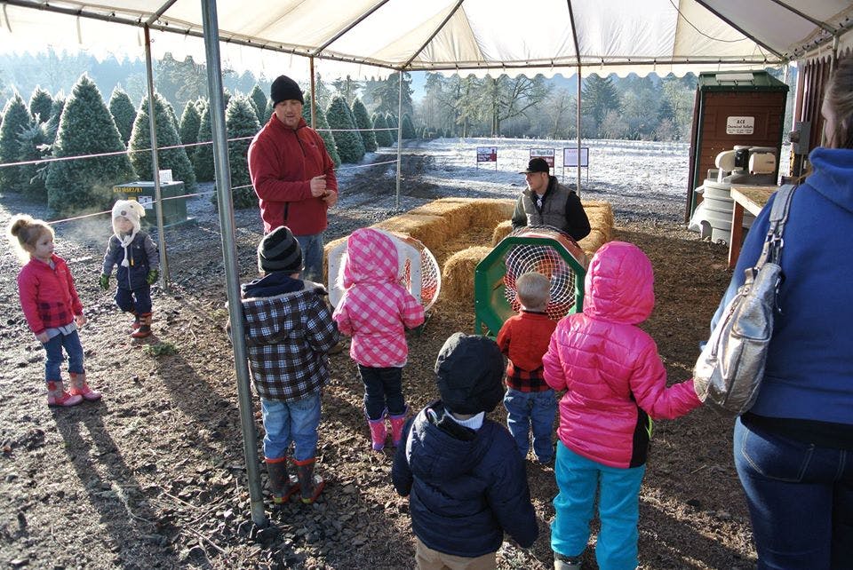 Adults and children gathered under a tent