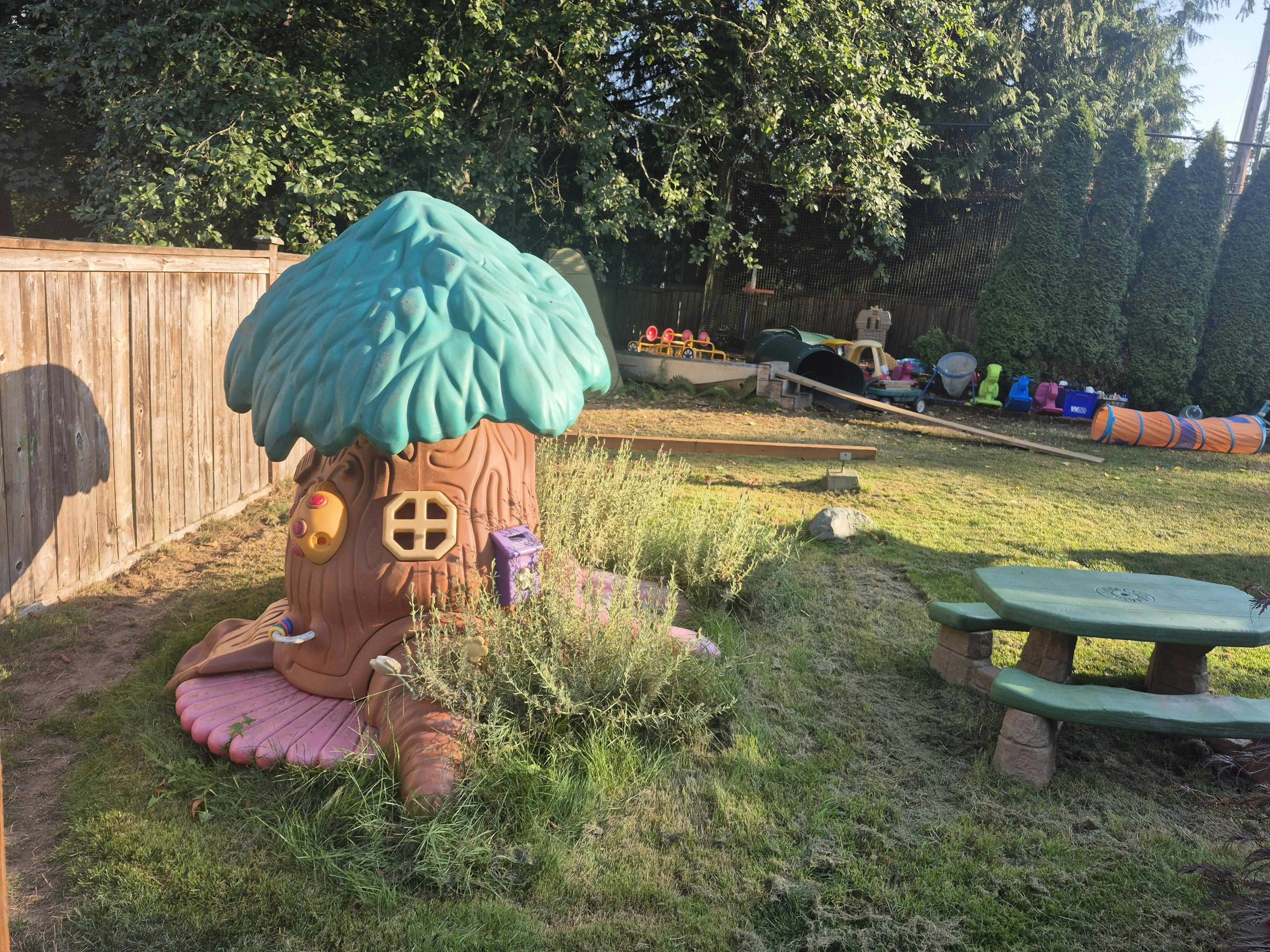 Playground with a tree stump playhouse and a picnic table