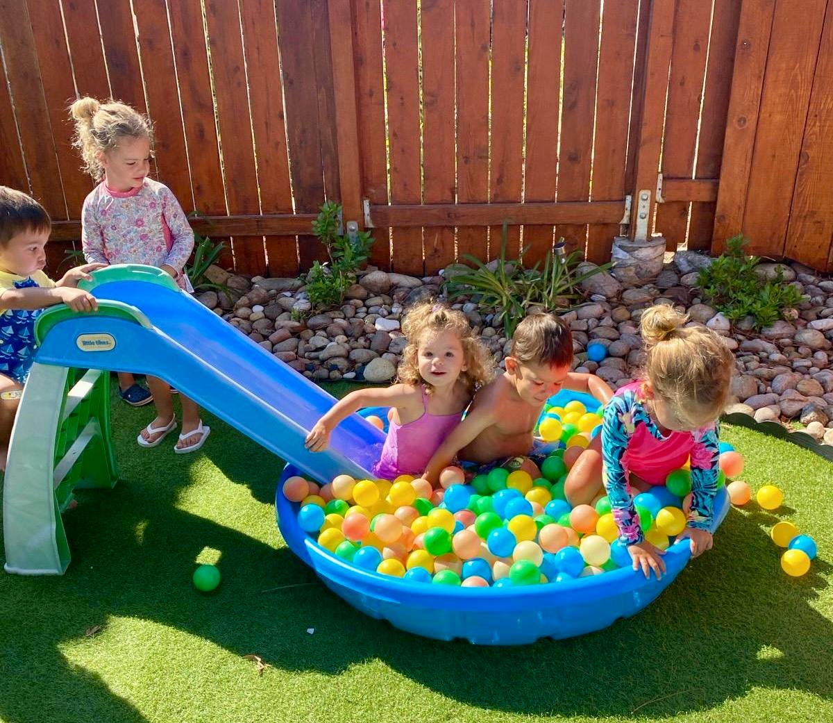 Children playing in a ball pit with a slide