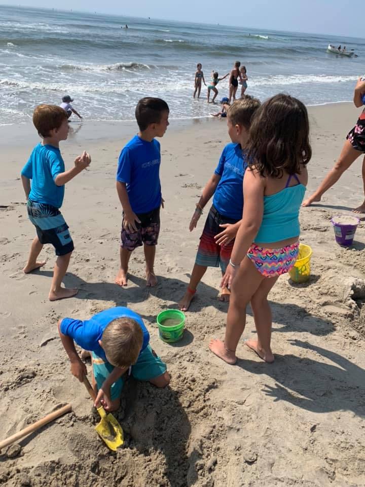 Children playing on a sandy beach near the ocean