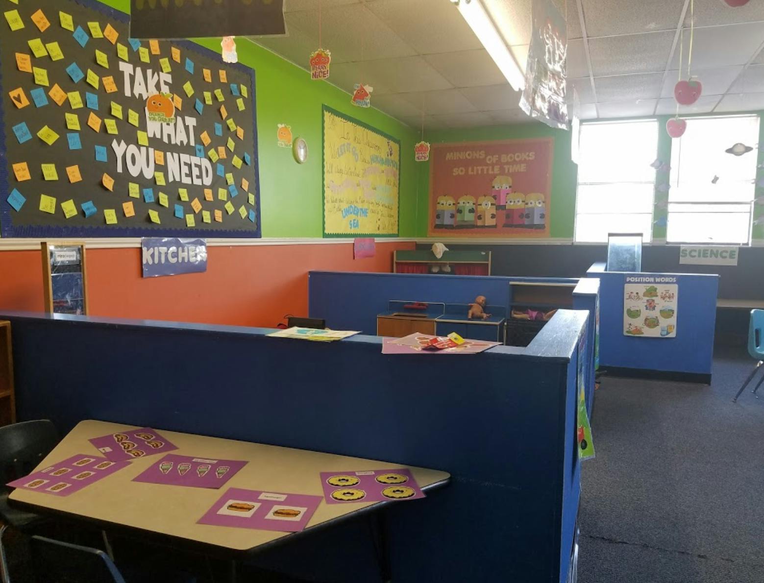 Classroom with blue dividers and a bulletin board that says "Take What You Need"