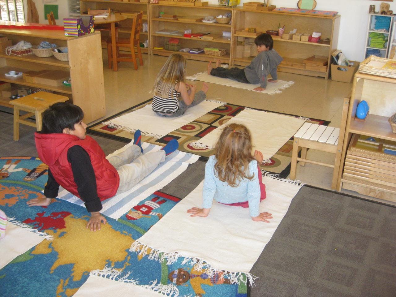 Children sitting on rugs in a classroom