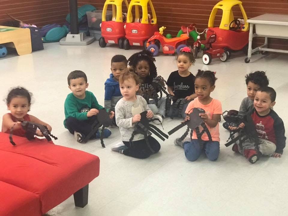 Group of children sitting on the floor holding toys