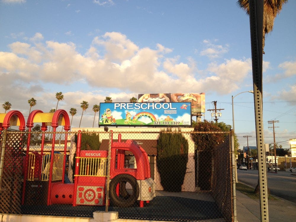 Playground with a red fire truck structure and a "PRESCHOOL" sign