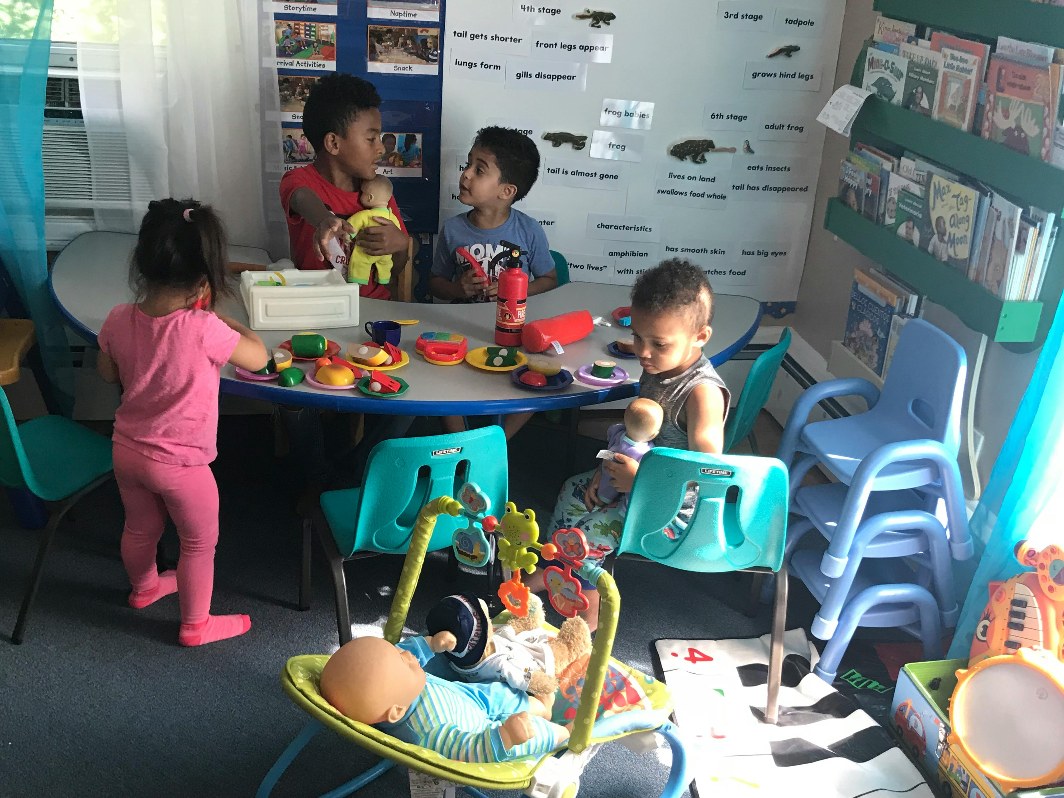Four children playing with toys around a small table