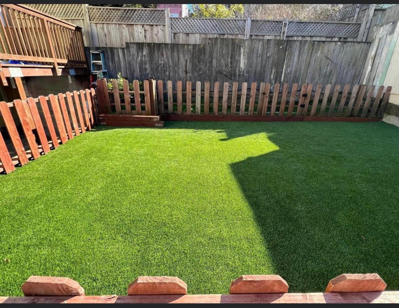 Backyard with artificial turf and wooden fences