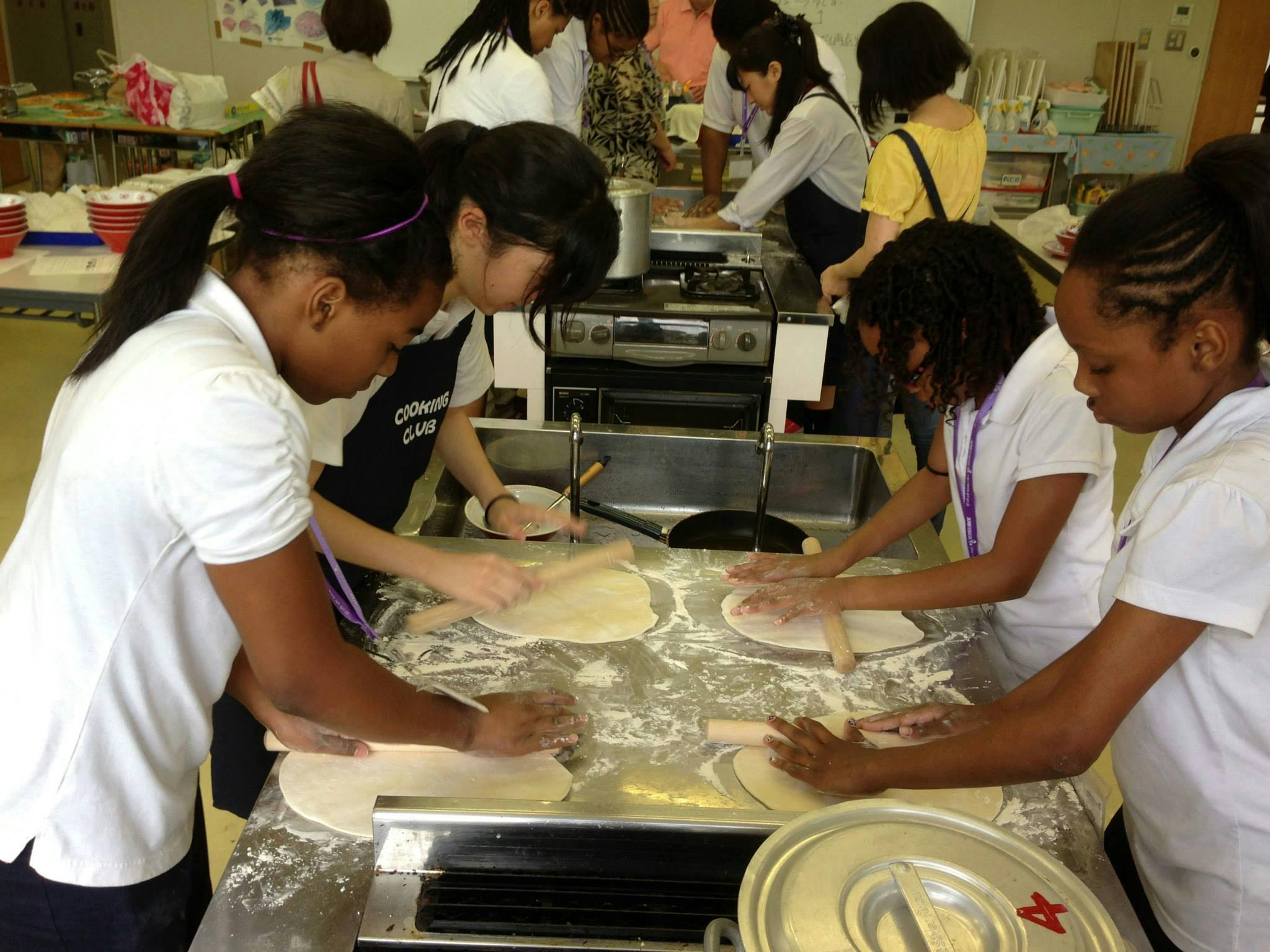 People rolling dough in a kitchen