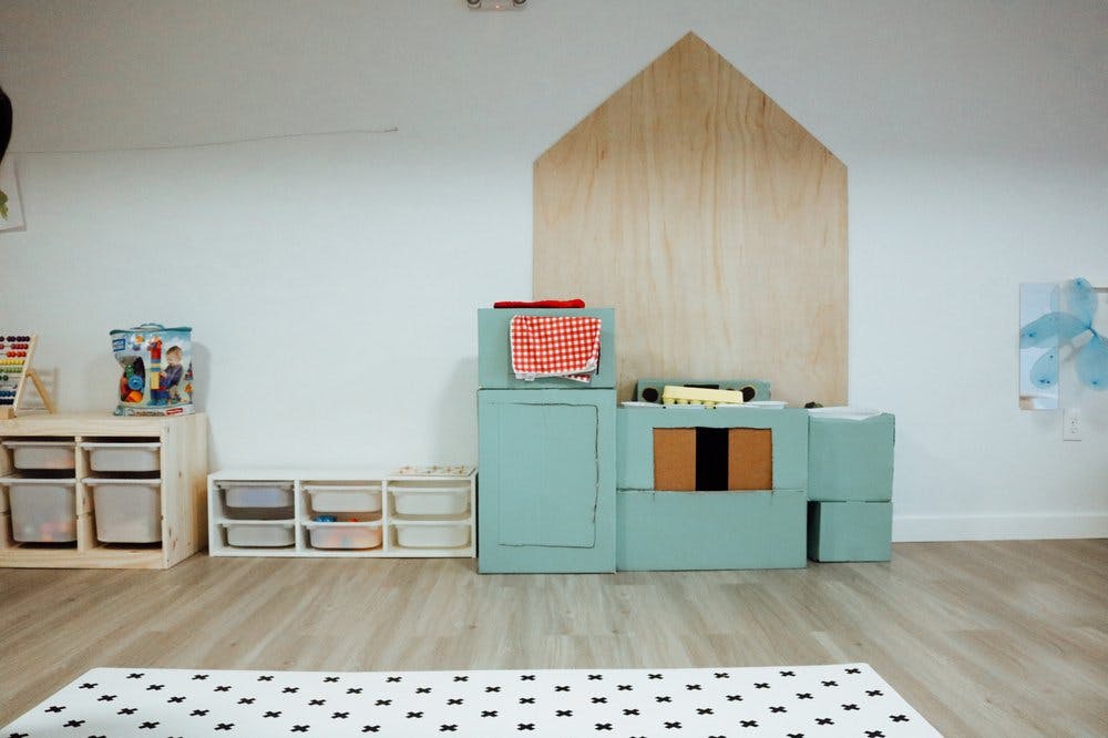 Playroom with toy kitchen set and storage shelves