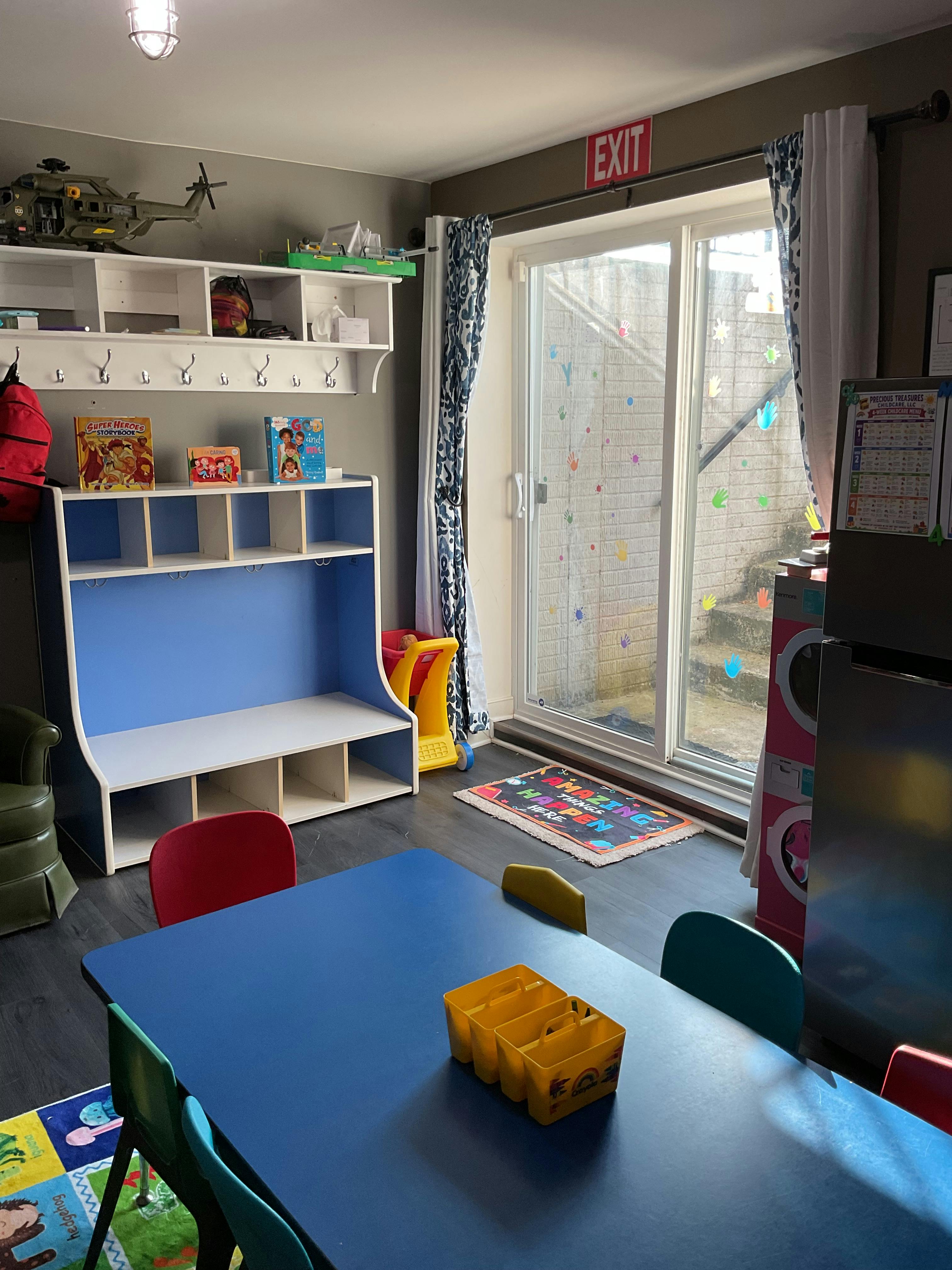 Childcare classroom with colorful table, storage shelves, and play materials
