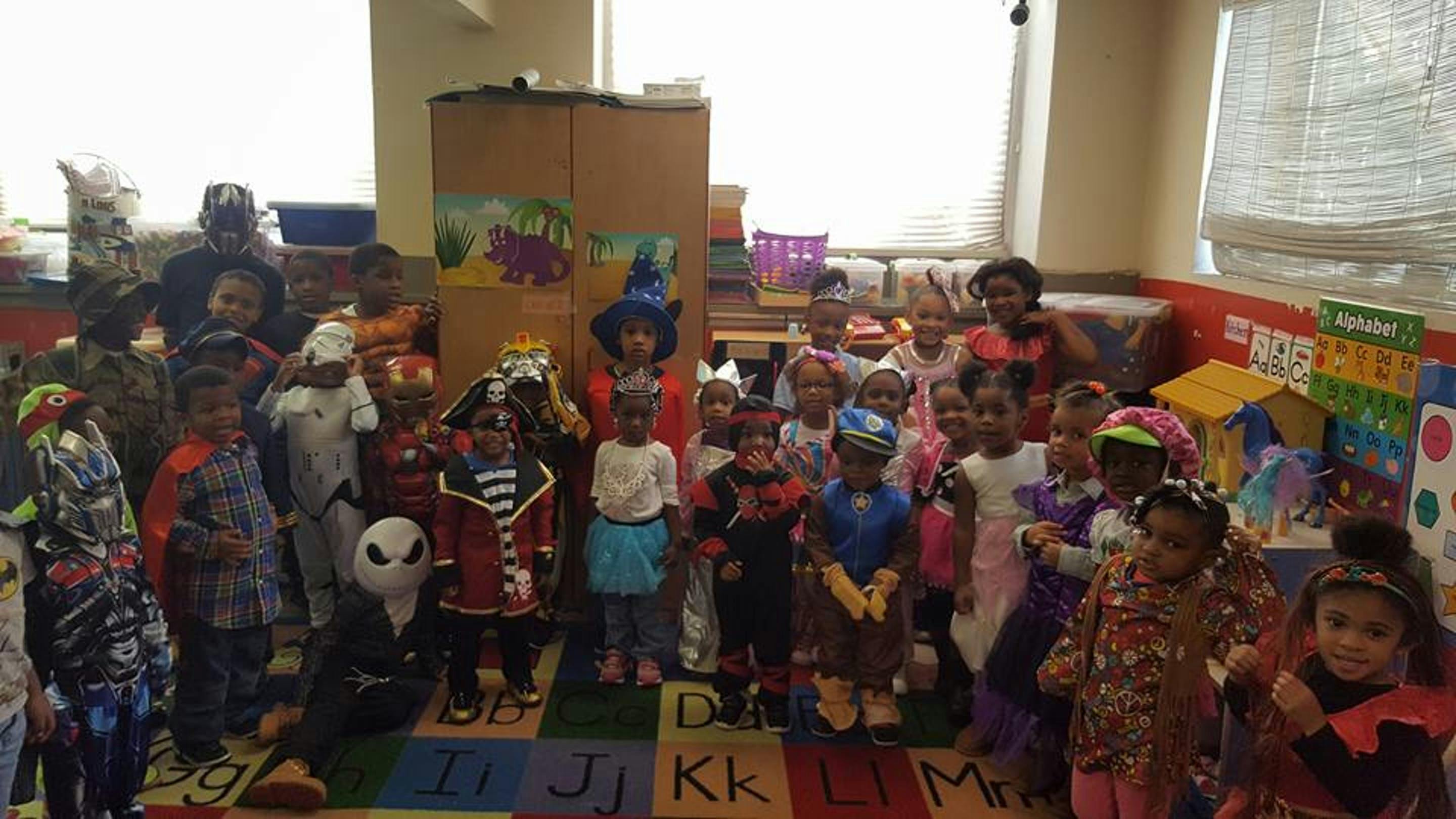 Group of children in costumes standing in a classroom