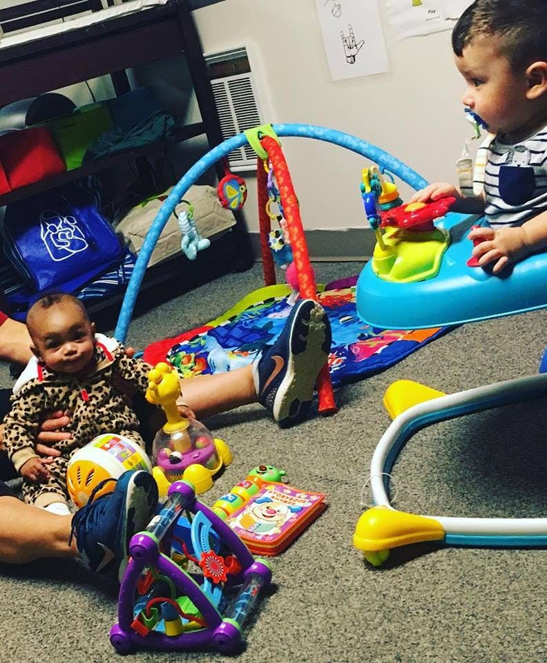 Two children playing with toys on a carpeted floor