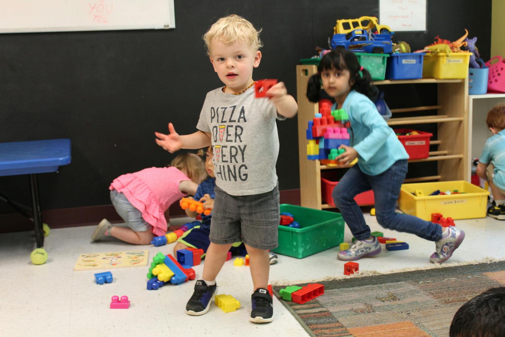 Children playing with colorful building blocks in a classroom