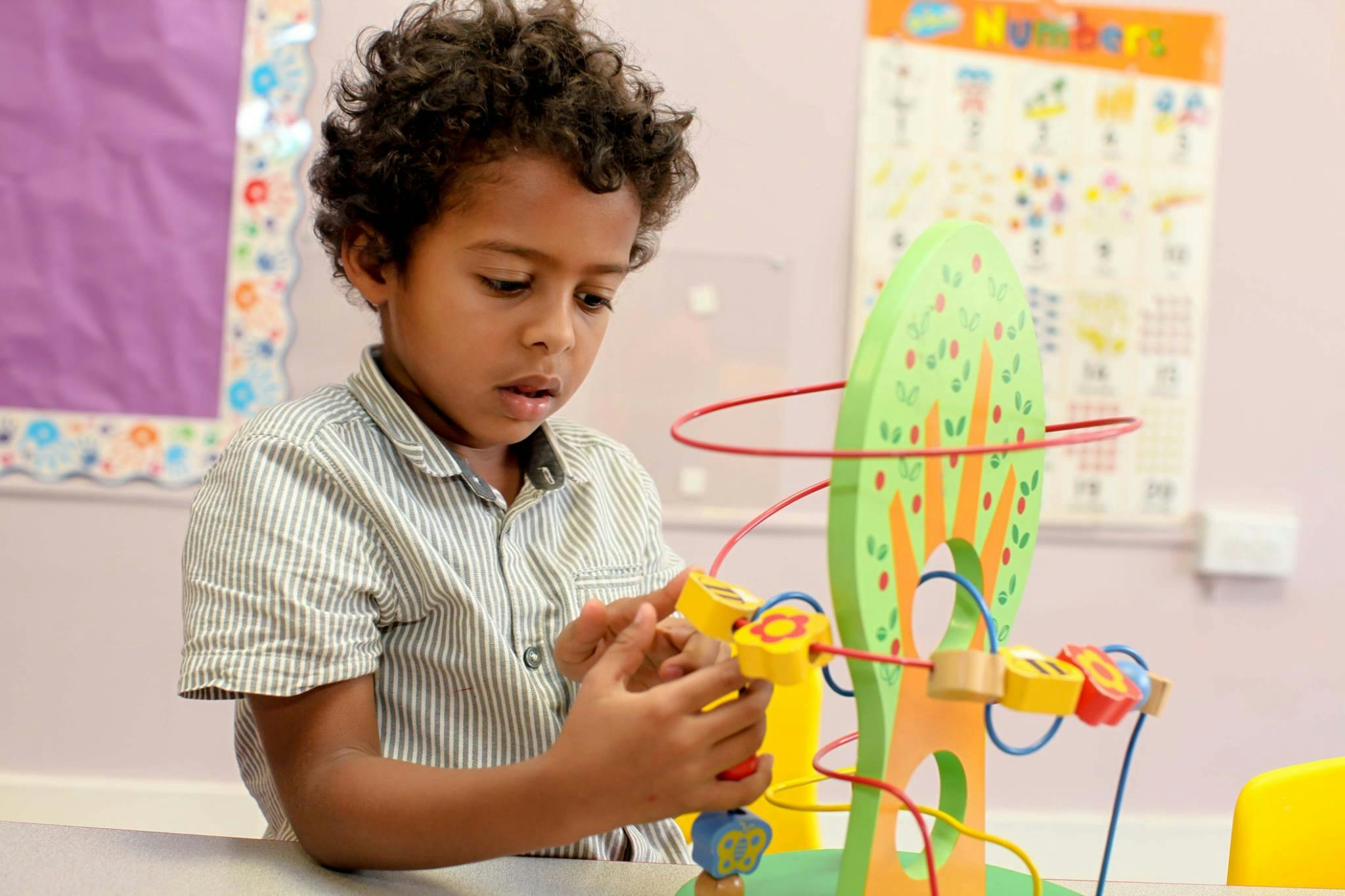 Child playing with a bead maze toy