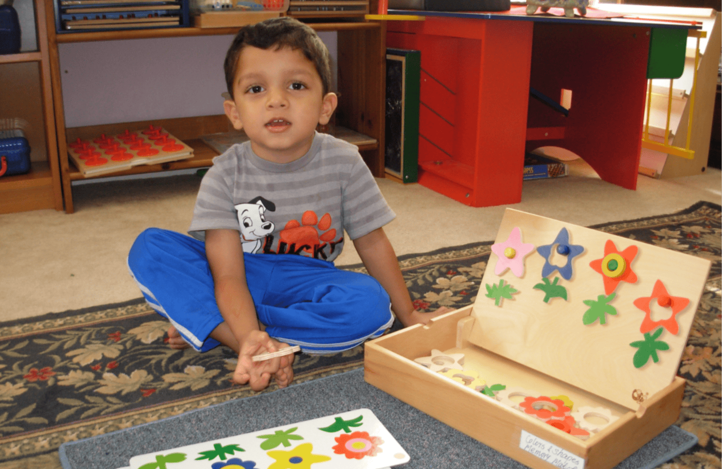 Child sitting on floor with a wooden puzzle toy