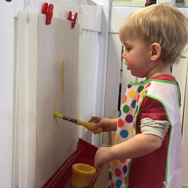Child painting on an easel with a brush