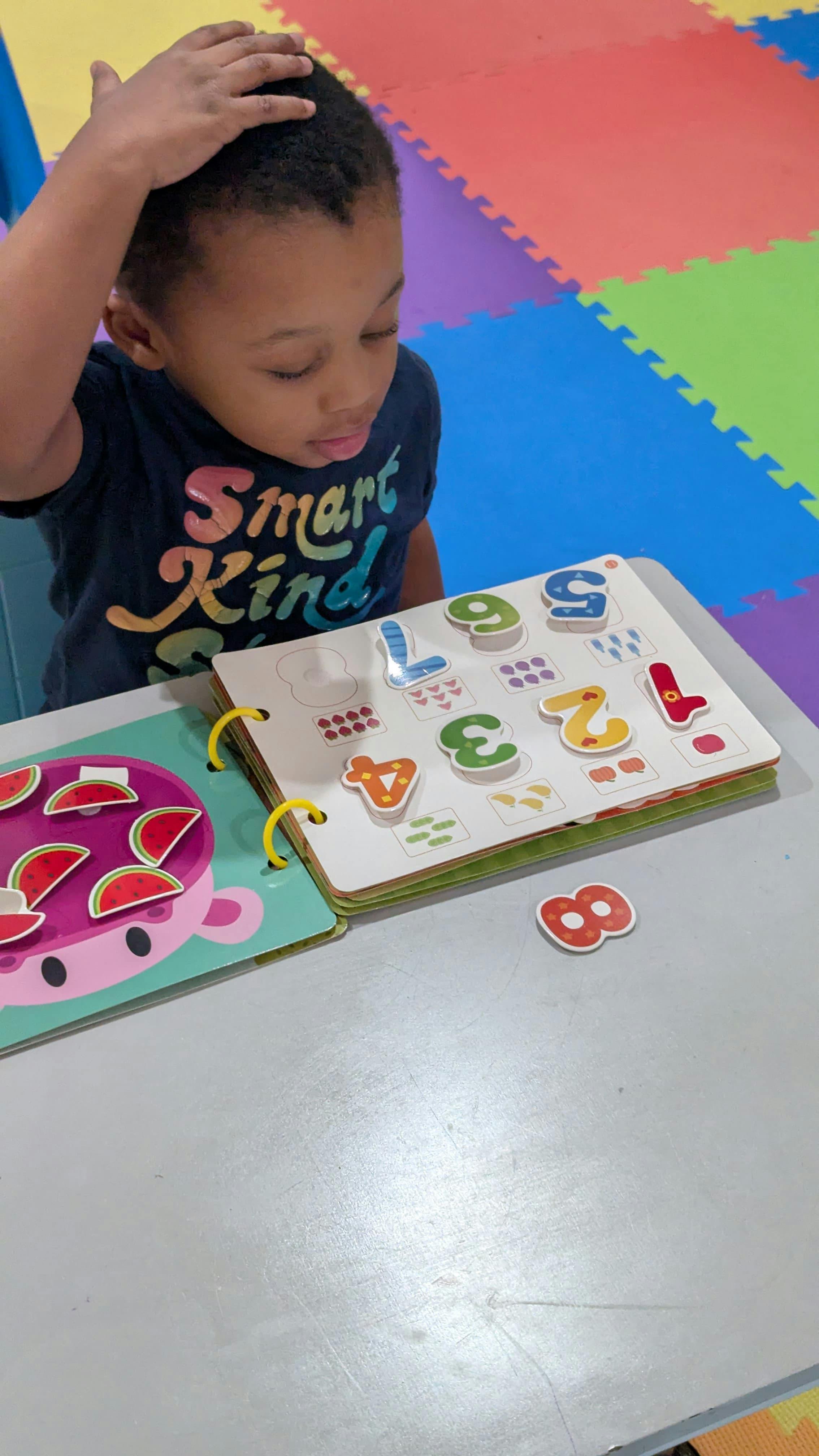 Child playing with a number-themed learning book