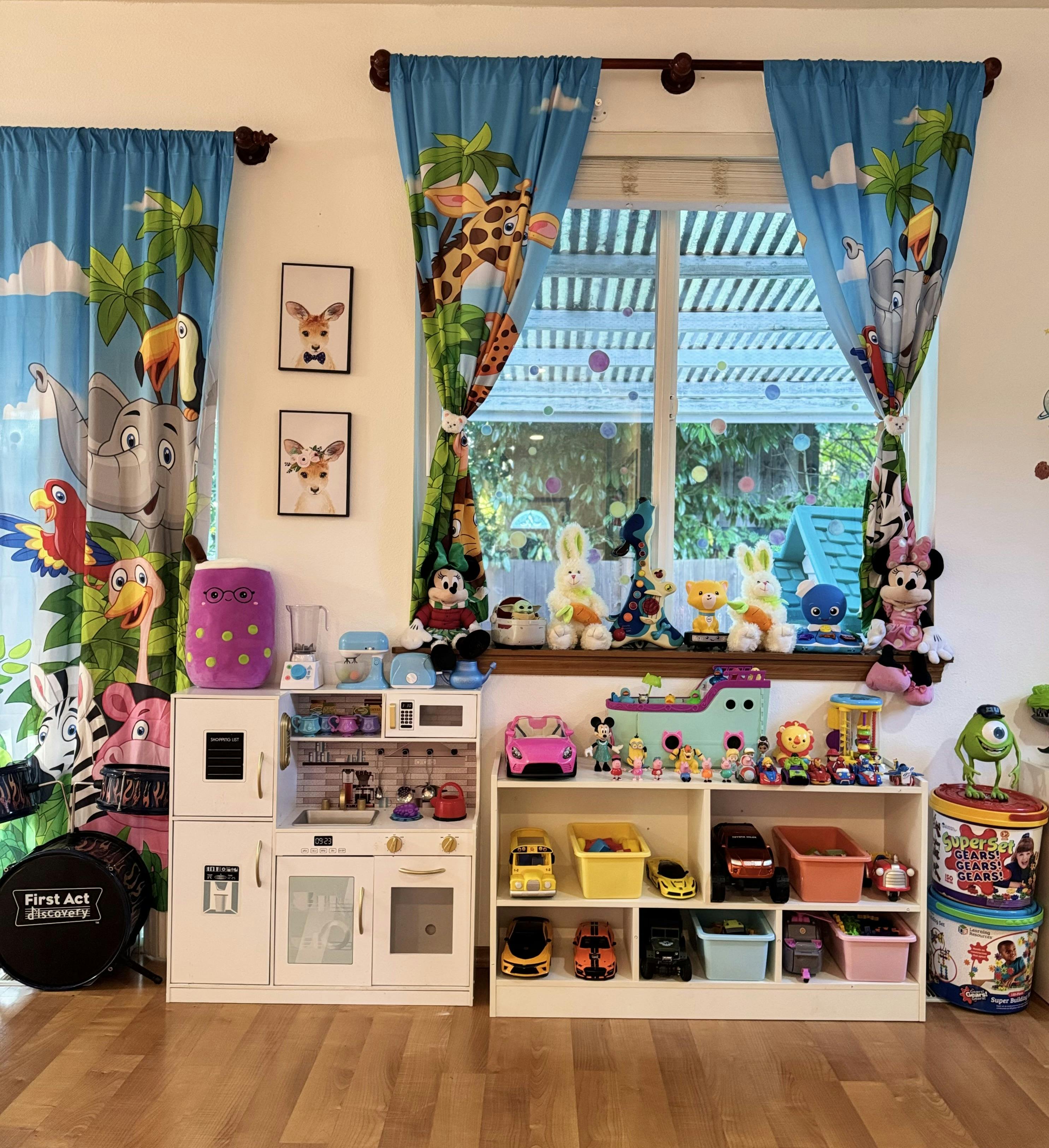 Playroom with toy kitchen, shelves of toys, and animal-themed curtains