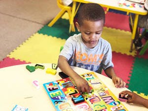 Child playing with a puzzle at a table