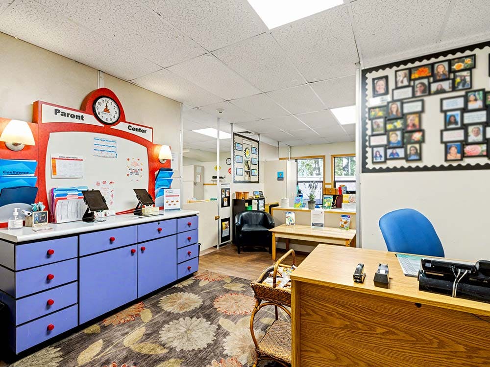 Parent Center room with storage, whiteboard, and various photographs on the wall