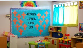 Classroom with a bulletin board that says "Jesus Lives For Us"