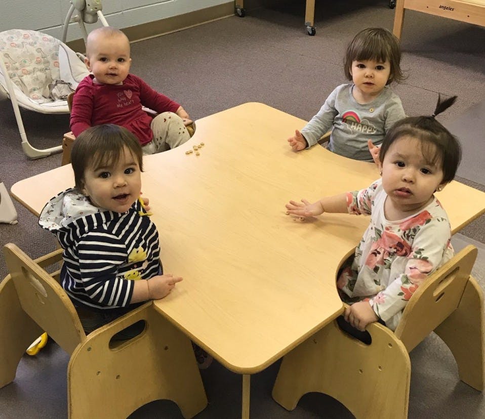 Four children sitting around a small wooden table