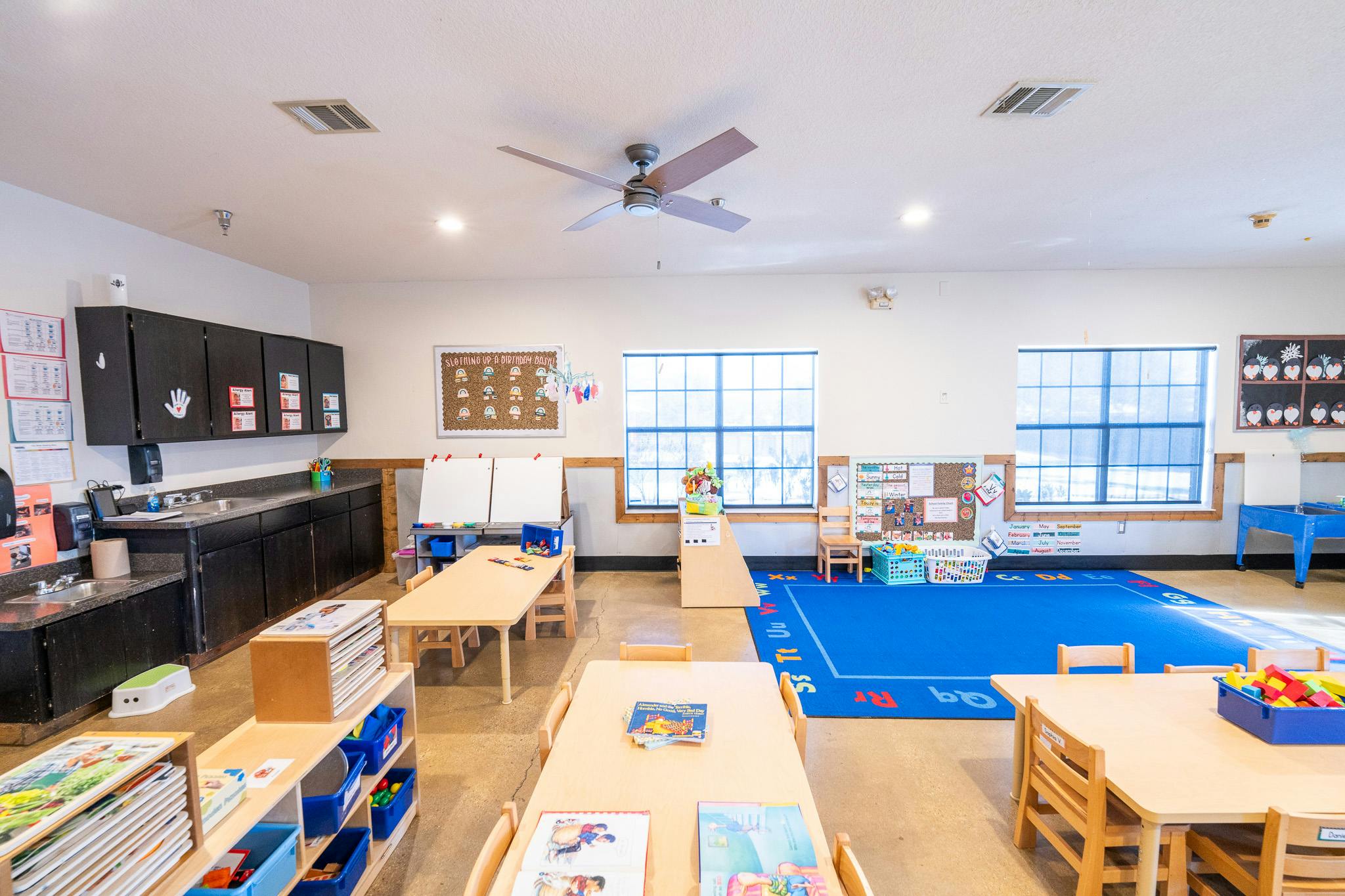 Classroom interior with tables, chairs, and learning materials