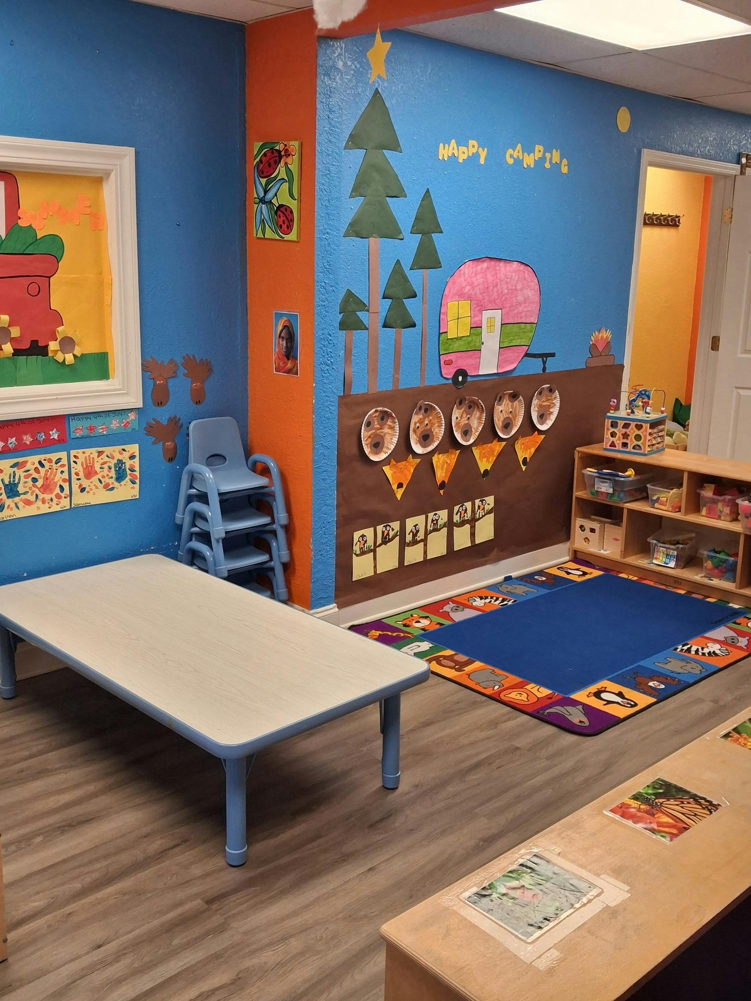 Camping themed classroom wall decorations with paper cutouts and tables