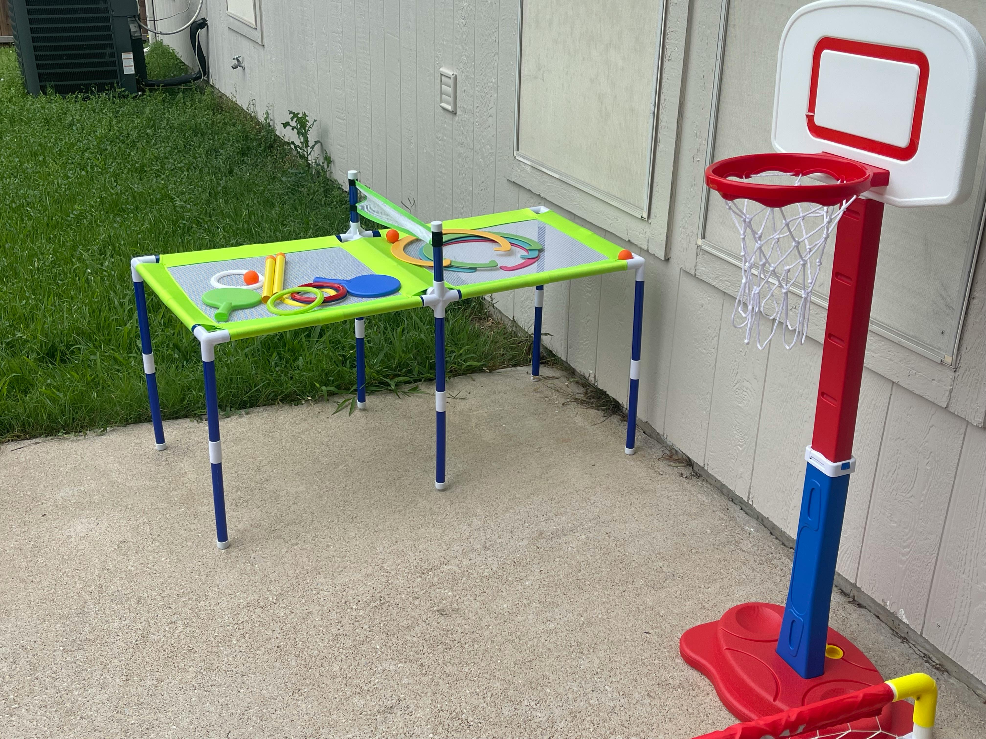 Outdoor play area with a children's basketball hoop and a play table