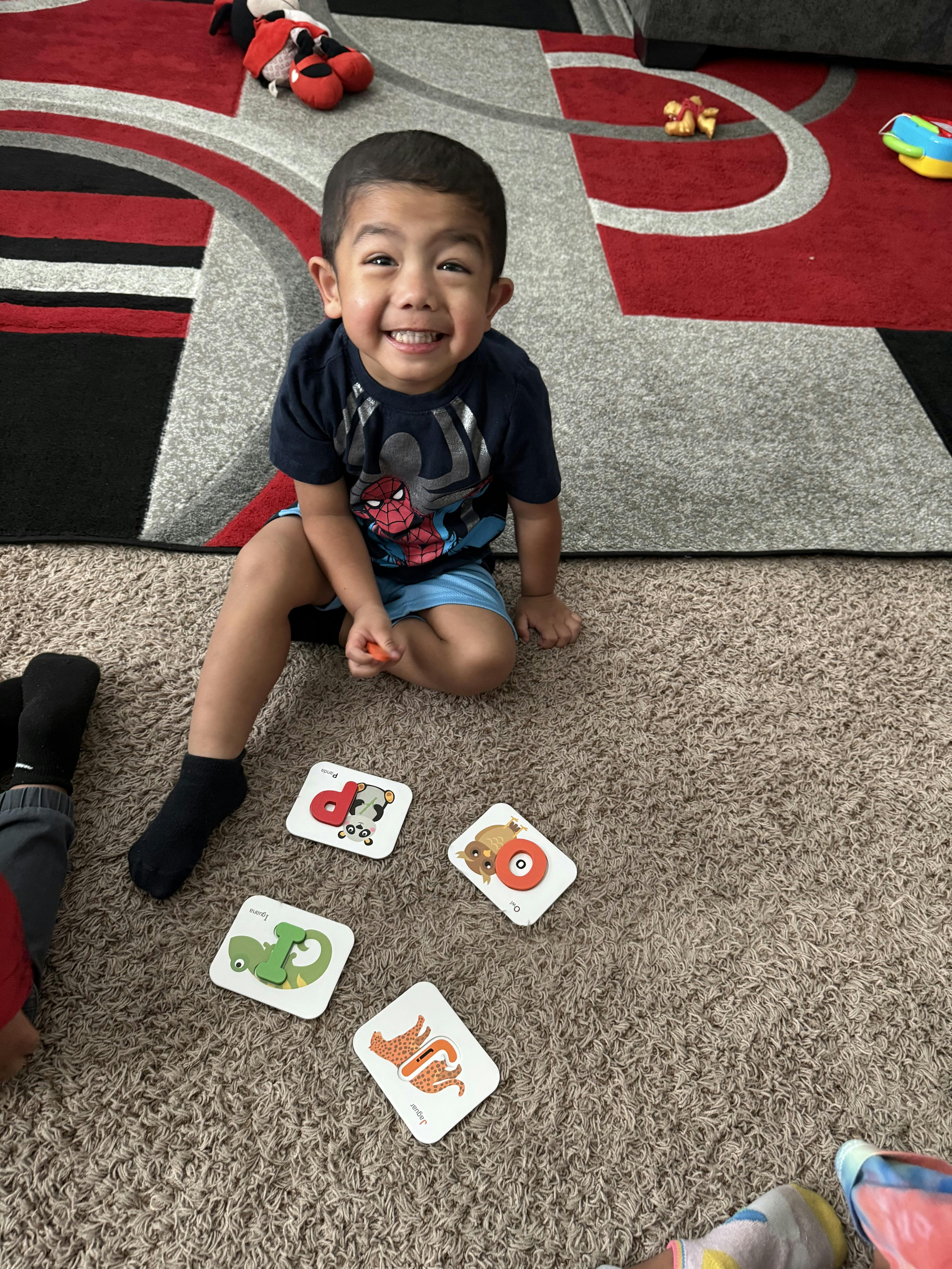 Child sitting on a carpet with game cards
