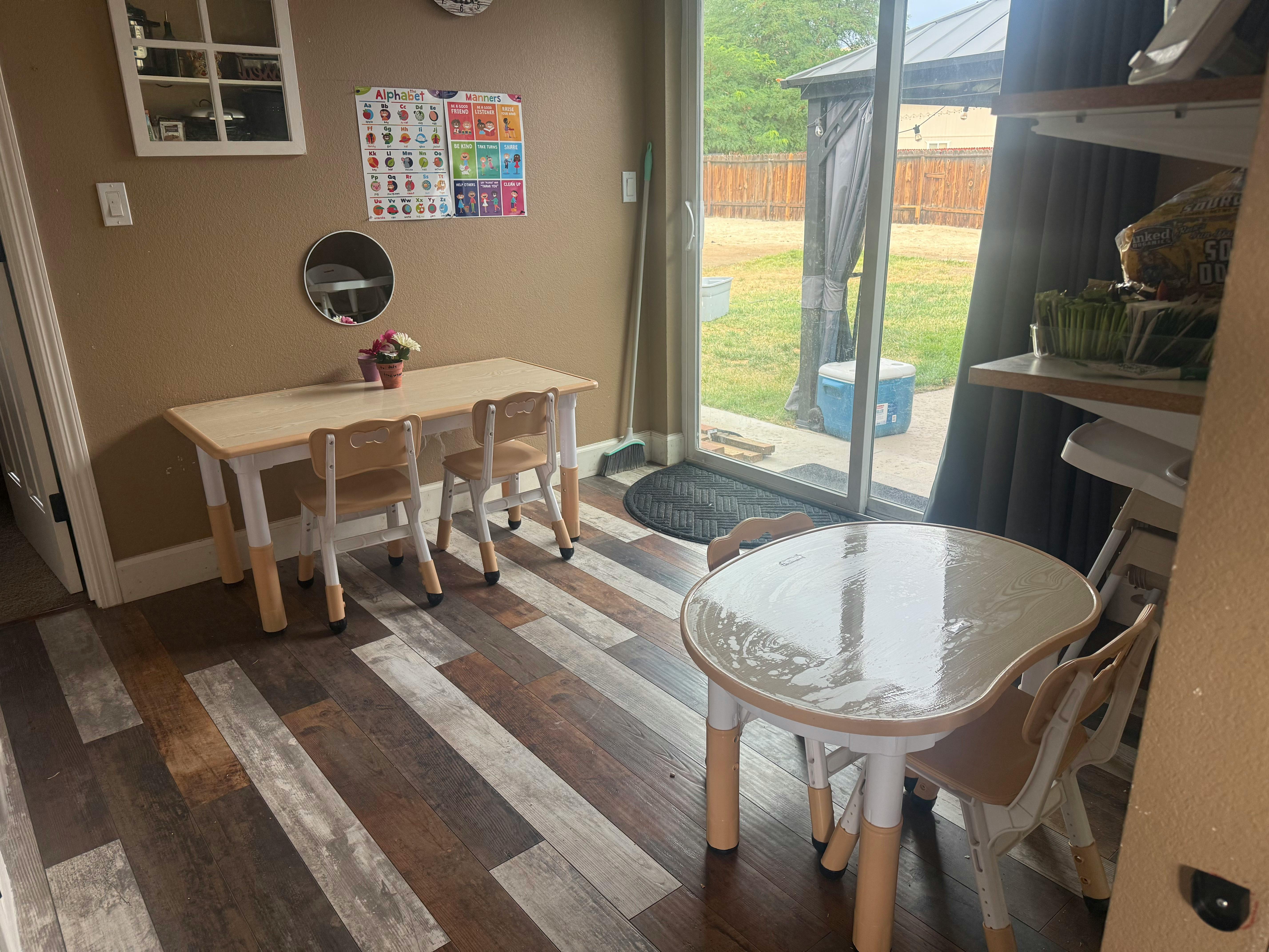 Two small tables with chairs in a room with a sliding glass door