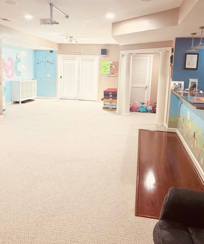 Room with light-colored carpet, blue walls, a white cabinet, and a projector