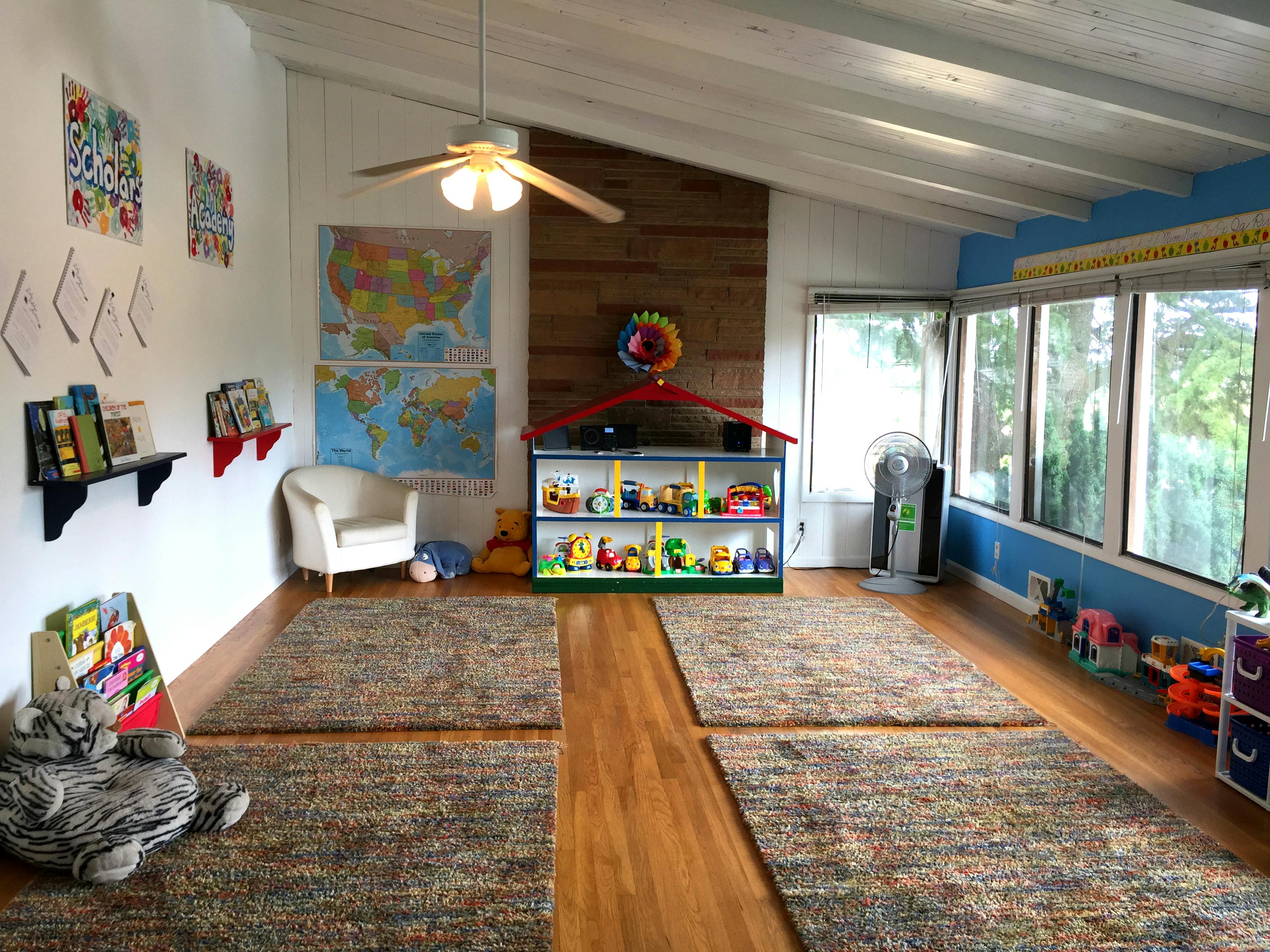 Playroom with rugs, shelves of toys, and maps on the wall maps and artwork
