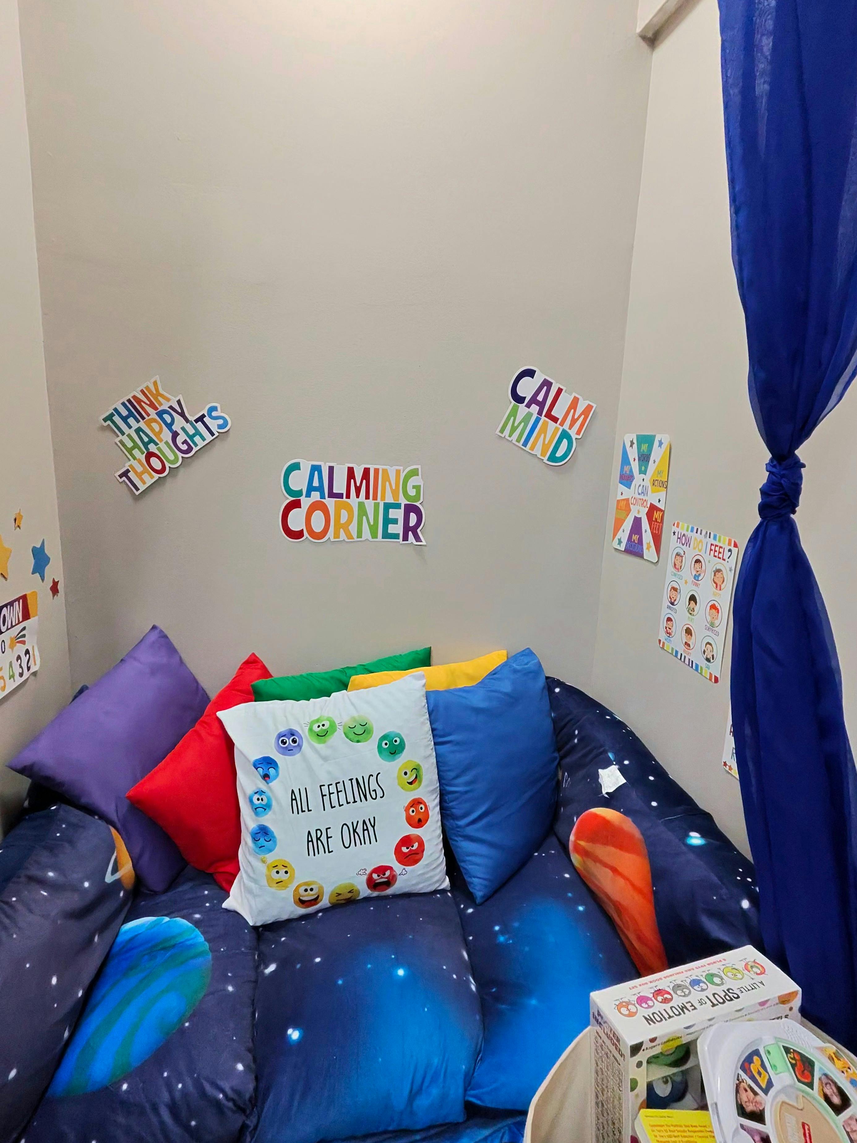 Calming corner with cushions and inspirational posters on the wall