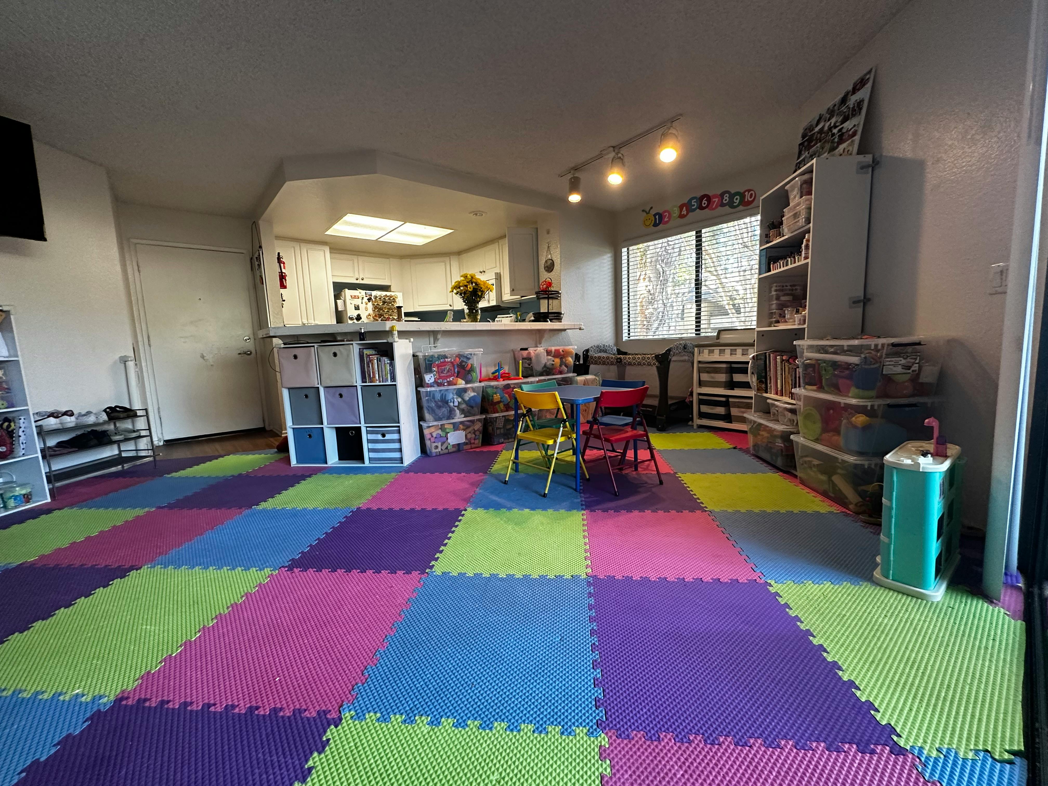 Playroom with colorful interlocking floor mats and small table with chairs