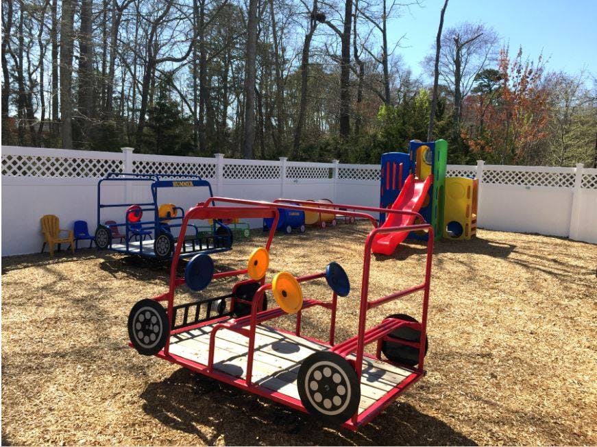 Playground with red and blue play structures and a colorful slide