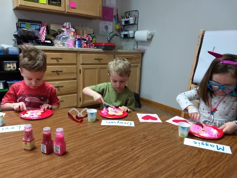 Three children doing an art activity at a table