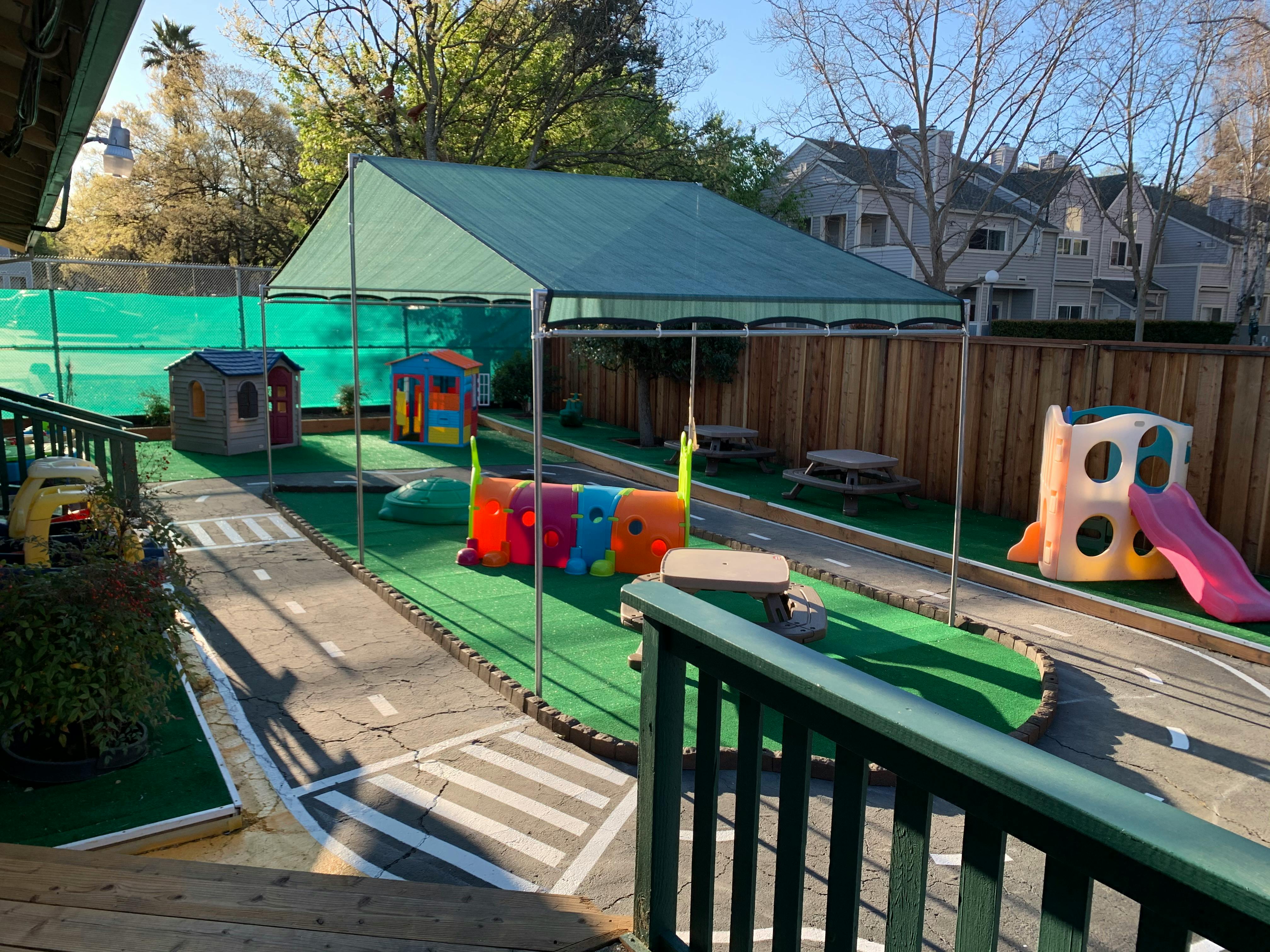 Outdoor playground with play structures, slides, and a miniature road
