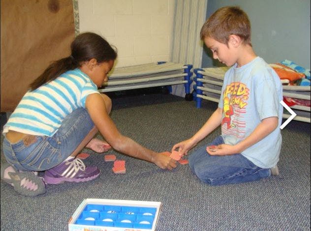 Two children playing with blocks on the floor