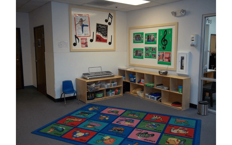 Room with children's rug, shelves with toys, a keyboard, and music-themed posters