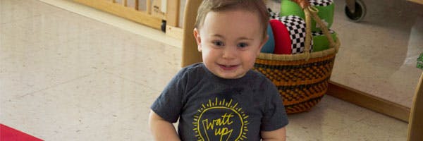 Child in a gray shirt with a lightbulb graphic