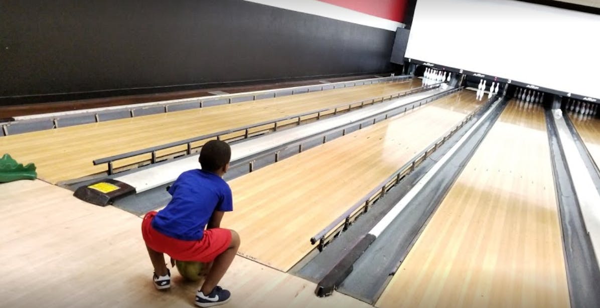 Person crouching at a bowling alley
