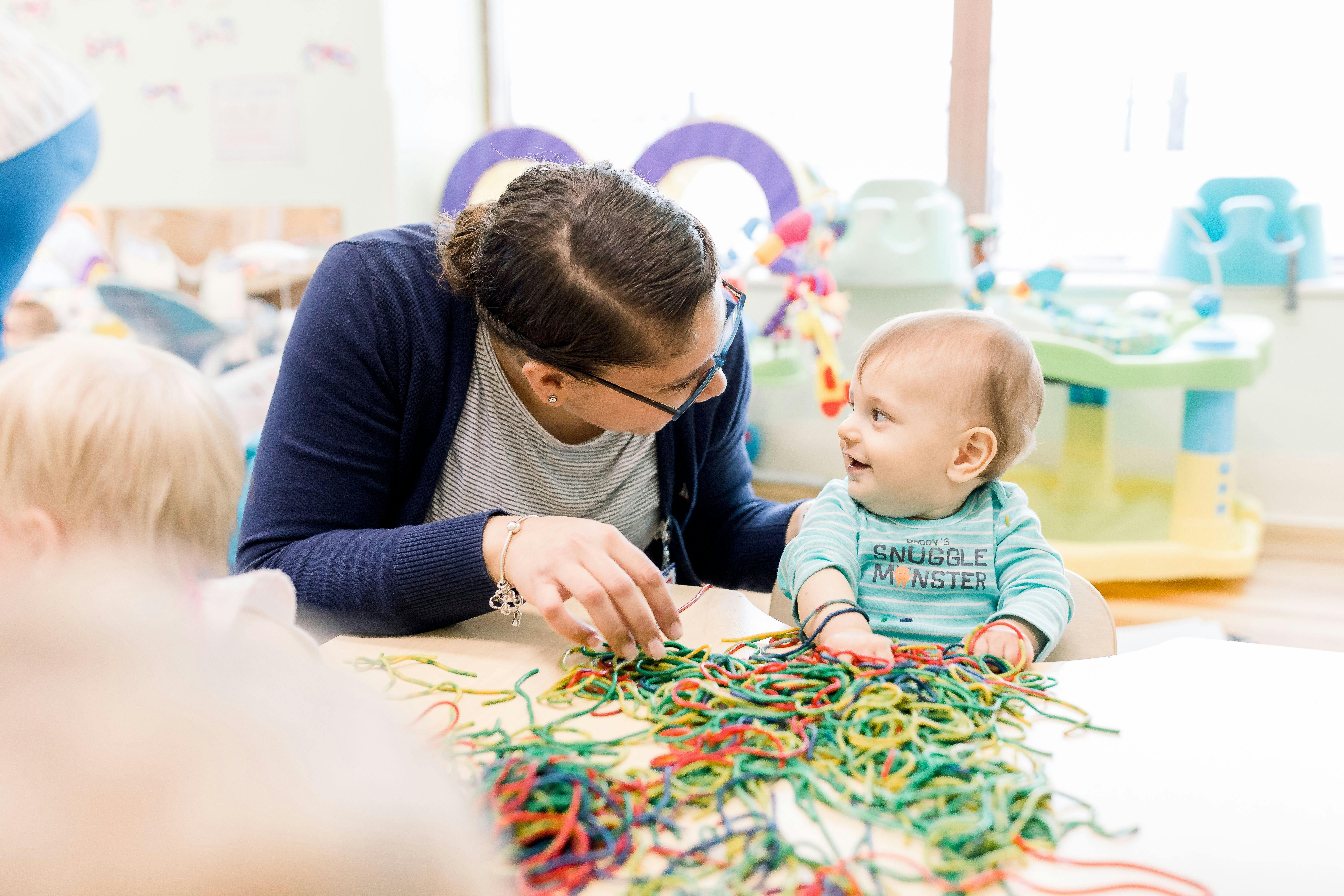 Adult and child playing with colorful strings
